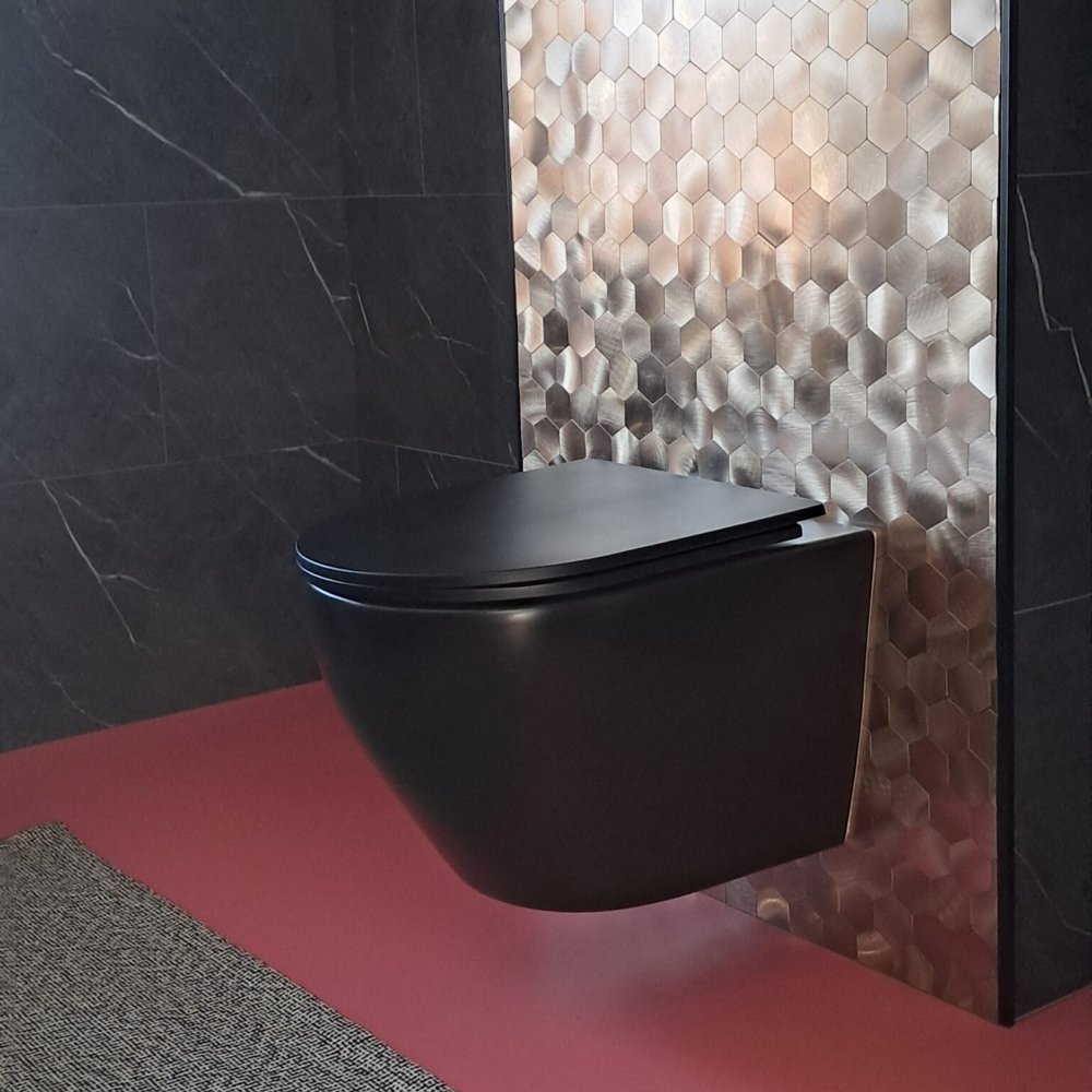 Gouden mozaïek plaktegels achter een zwart hangtoilet