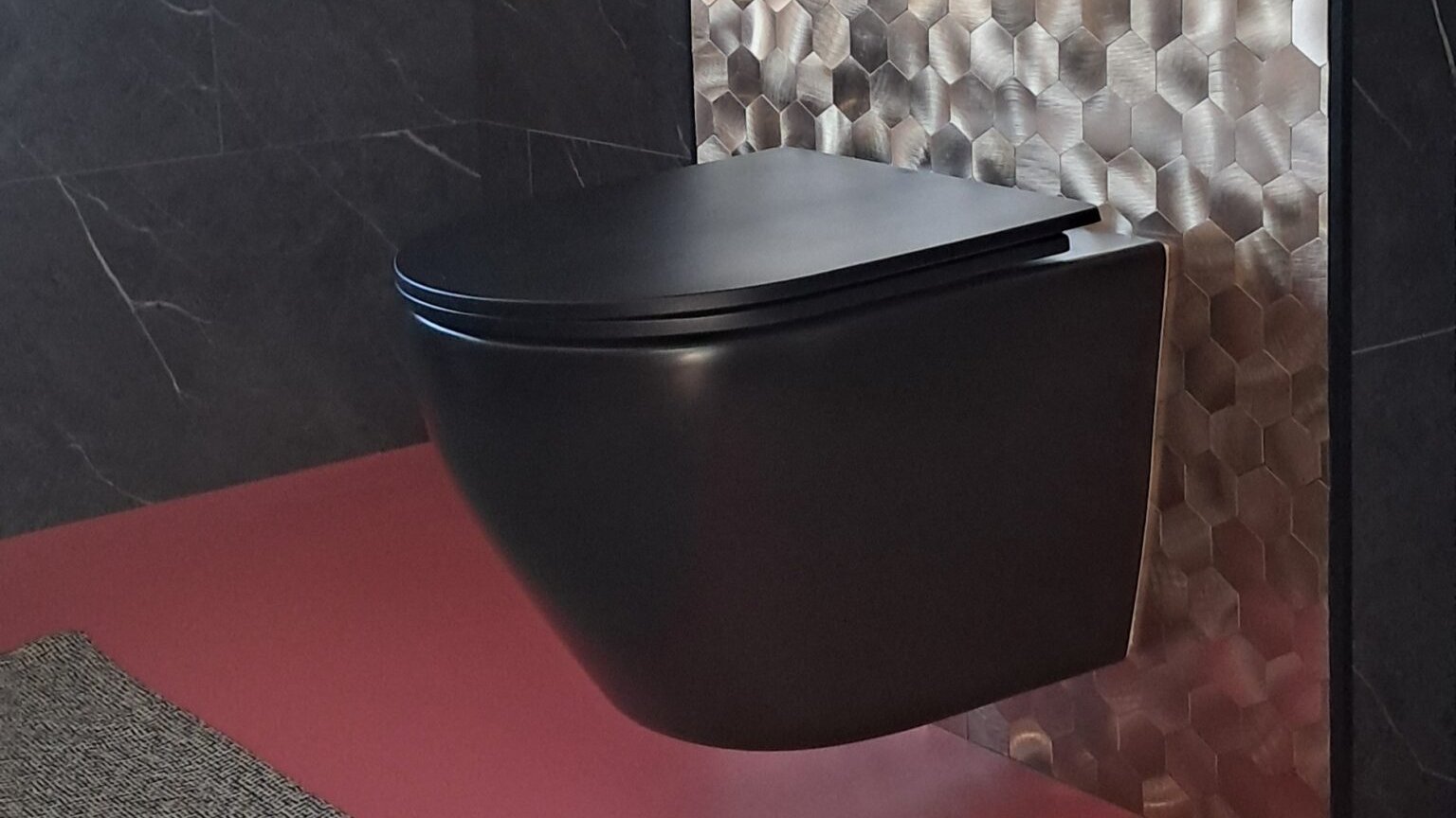 Plaktegels wc: gouden mozaïek plaktegels achter een zwart toilet