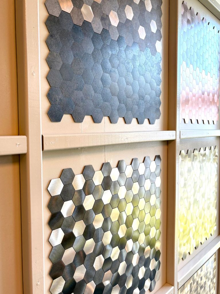 Wand met zelfklevende mozaïek plaktegels in hexagonvorm in de showroom in Velp