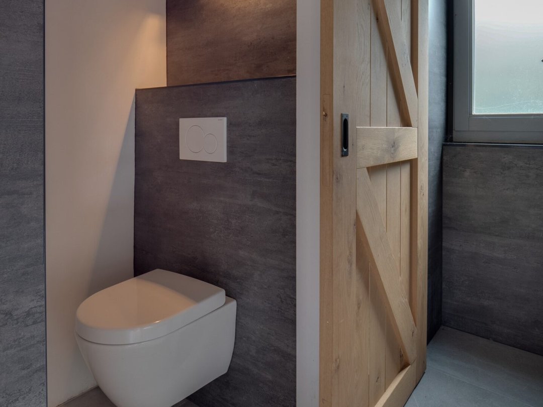 Grijze wandpanelen toilet in kalksteenlook